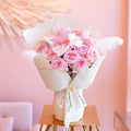 Bouquet of pink gardenia roses mix with white orchid and feather

